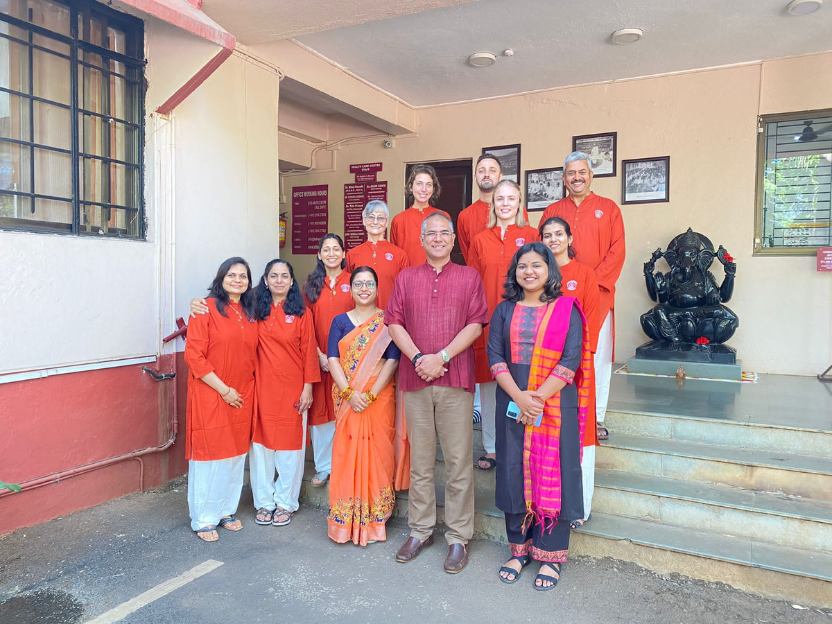 Group photo of yoga instructors and participants standing together outside a building